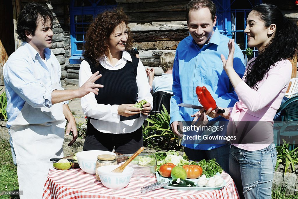 Side profile of a young woman standing with a mature man and a mid adult couple near a table