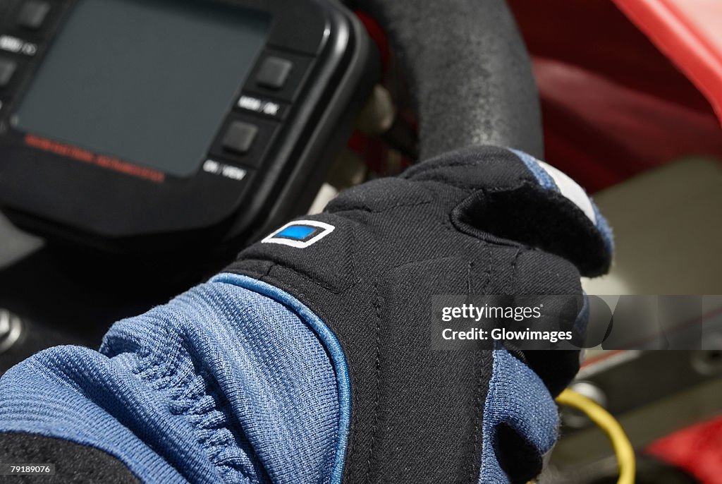 Close-up of a person's hand on the steering wheel of a go-cart