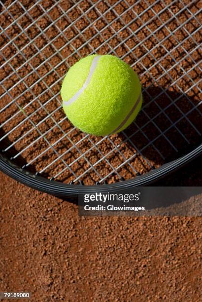 close-up of a tennis ball on a racket in a court - tennis raquet close up photos et images de collection