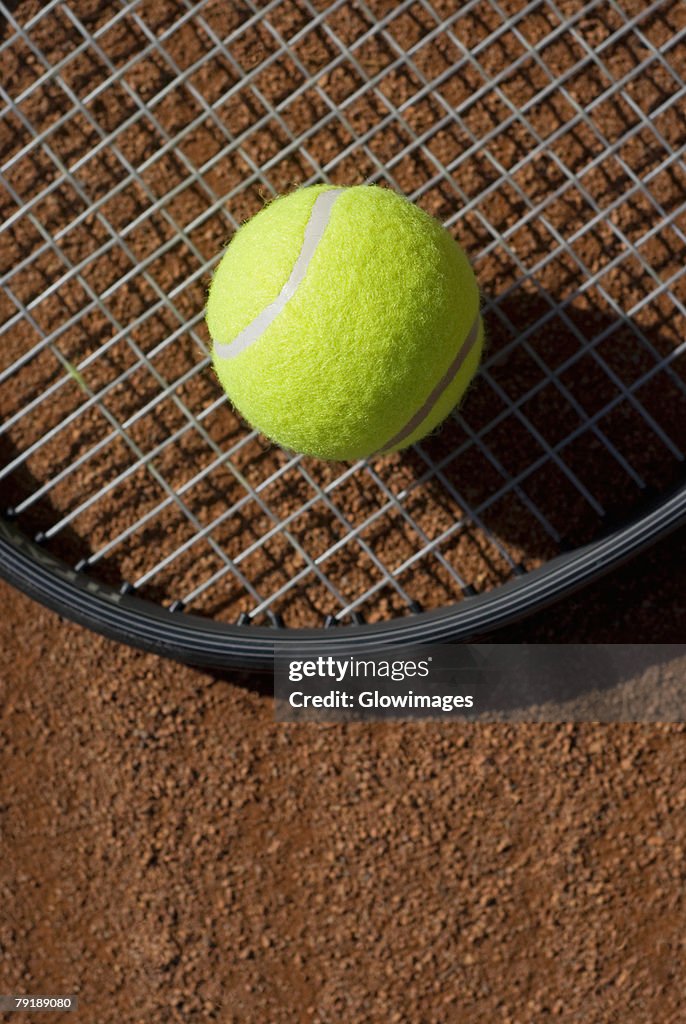 Close-up of a tennis ball on a racket in a court