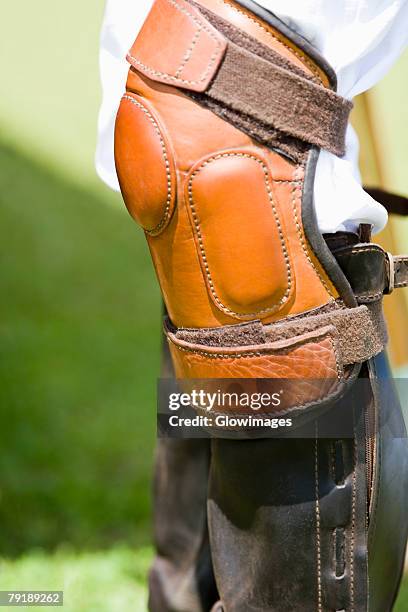 close-up of a person's legs wearing riding boots and a kneepad - kneepad stock pictures, royalty-free photos & images