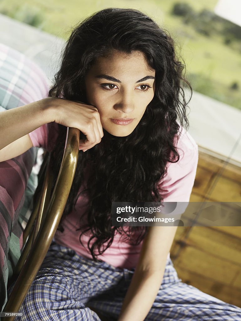 Young woman sitting on a chair and thinking