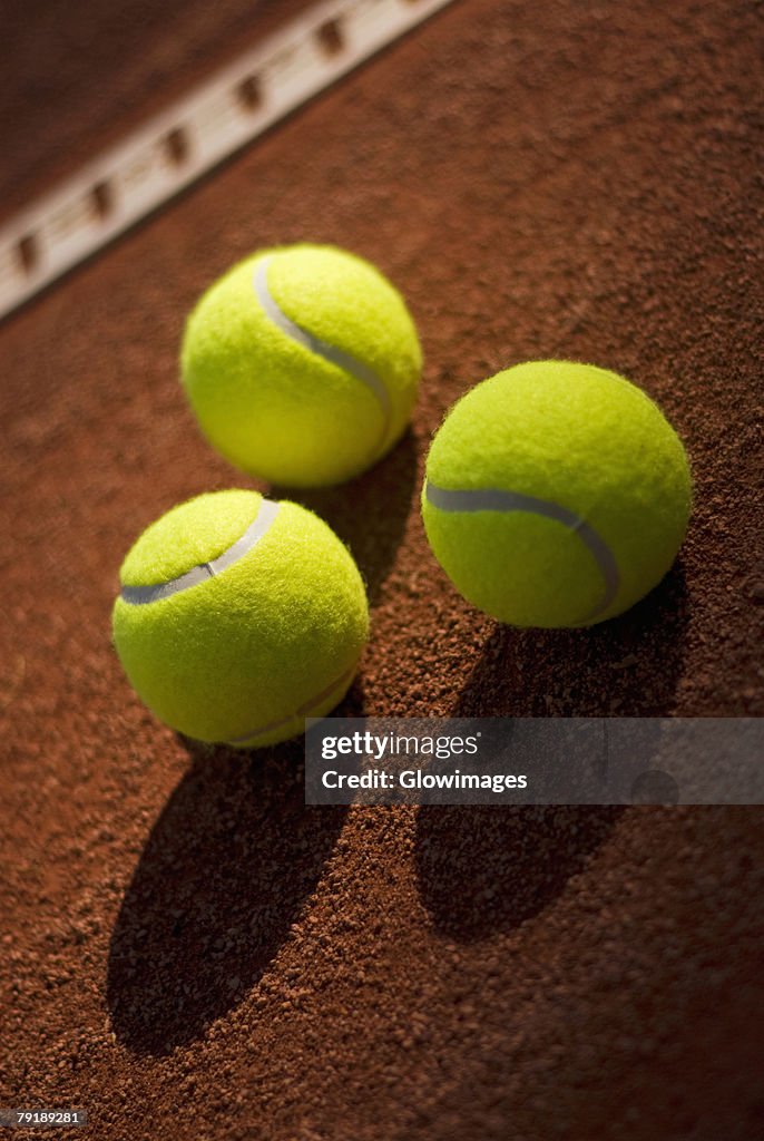 Close-up of three tennis balls in a court