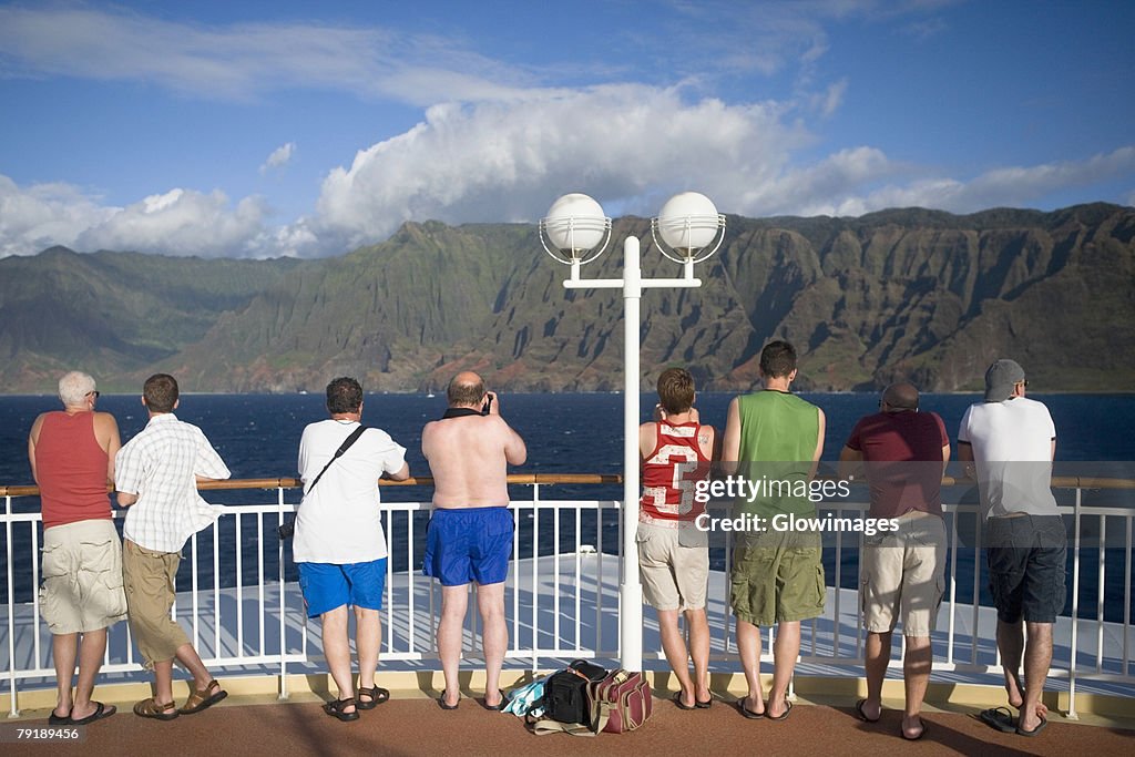 Rear view of tourists standing at observation point looking at a view, Na Pali Coast State Park, Kauai, Hawaii Islands, USA