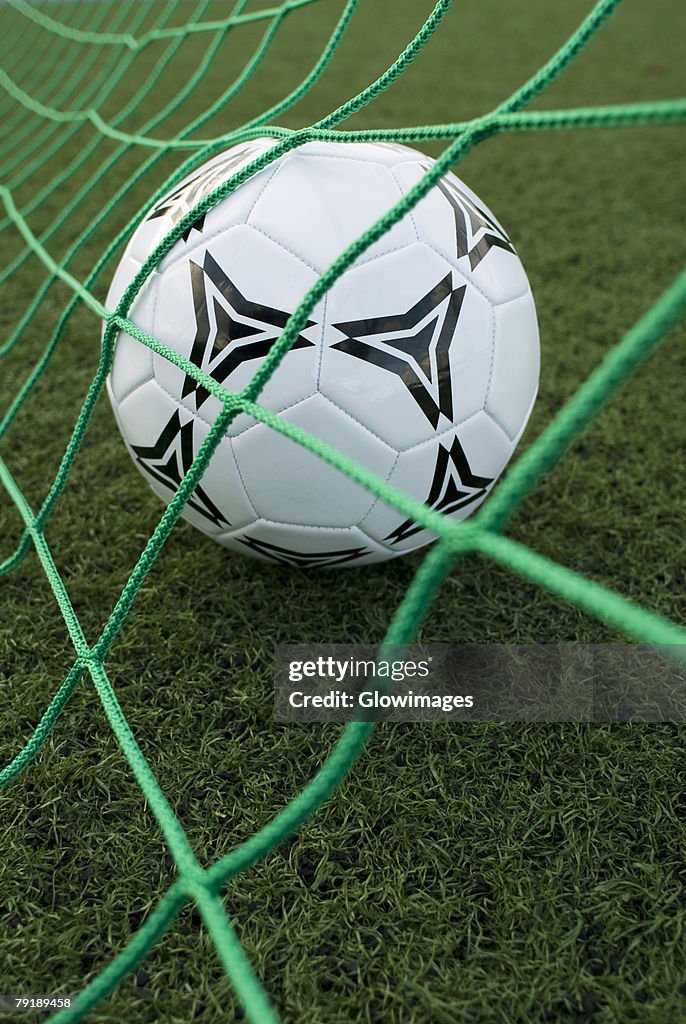 Close-up of a soccer ball in a goal post net