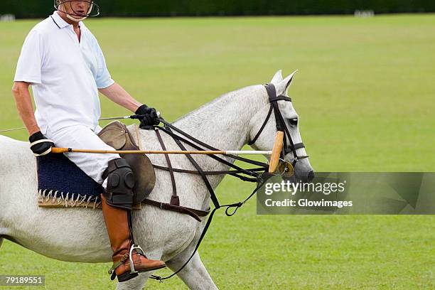 man playing polo - mazo fotografías e imágenes de stock