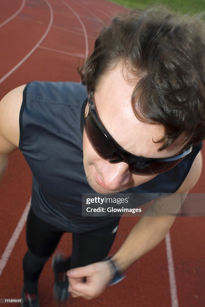 High angle view of a mid adult man running on a running track