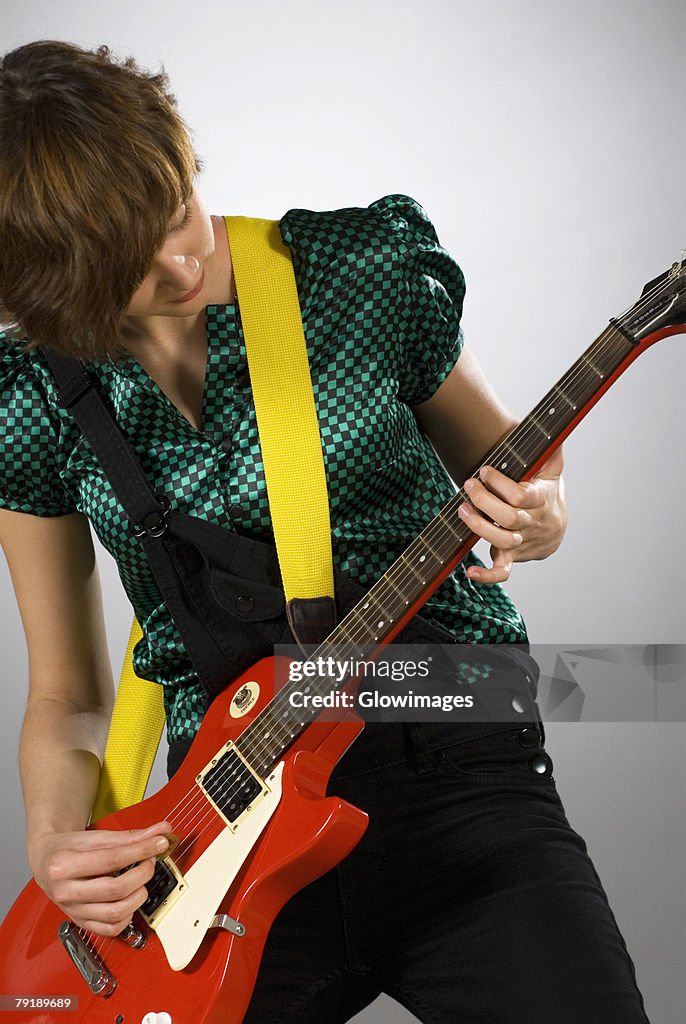 Close-up of a female guitarist playing a guitar