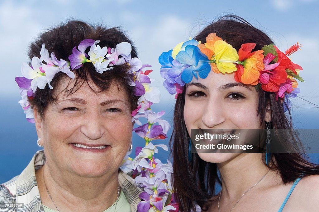 Portrait of a senior woman and her daughter wearing flowers