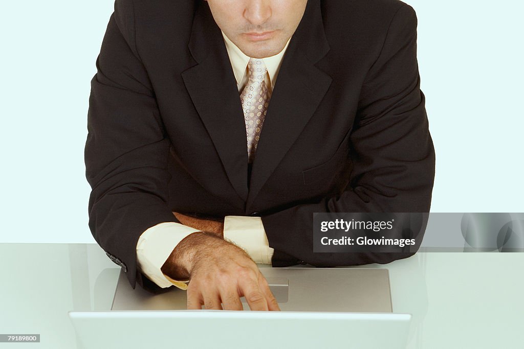 Mid section view of a businessman using a laptop