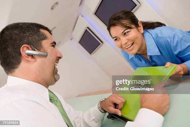 businesswoman giving a file to a businesswoman and smiling - business person handing over a letter fotografías e imágenes de stock