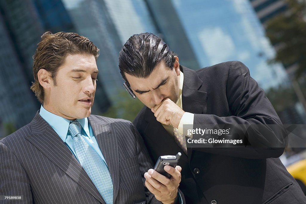 Two businessmen looking at a hand held device