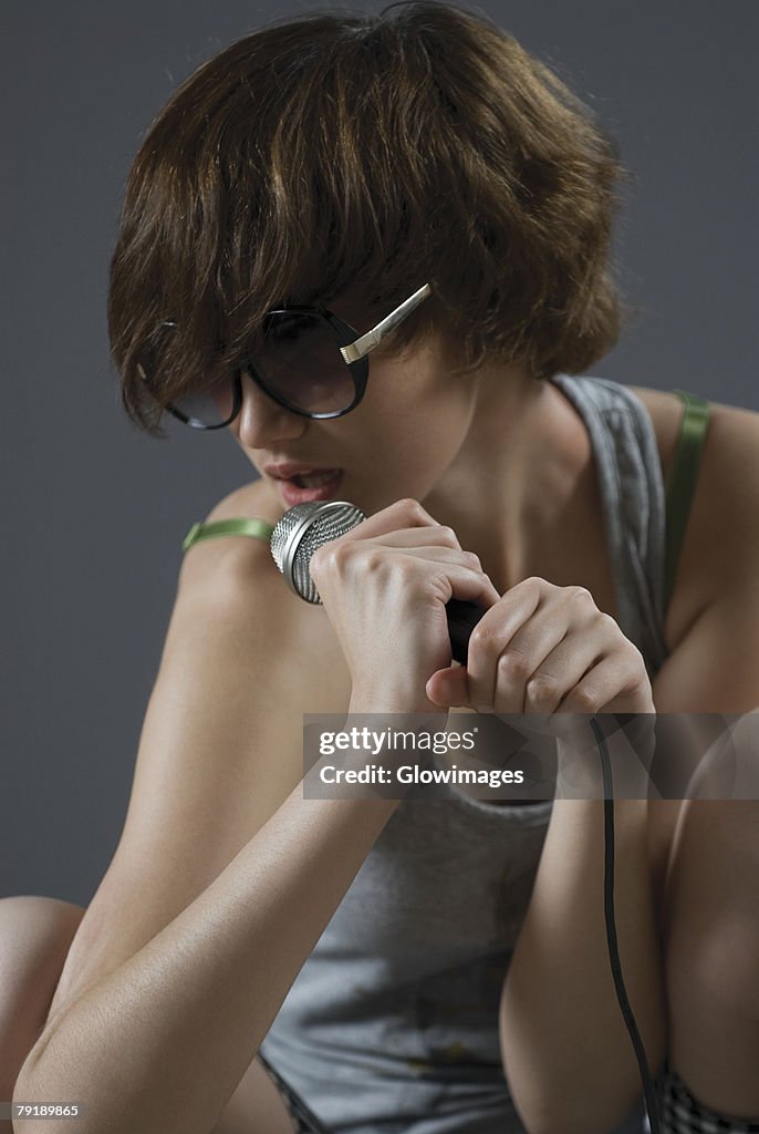 Close-up of a young woman singing into a microphone