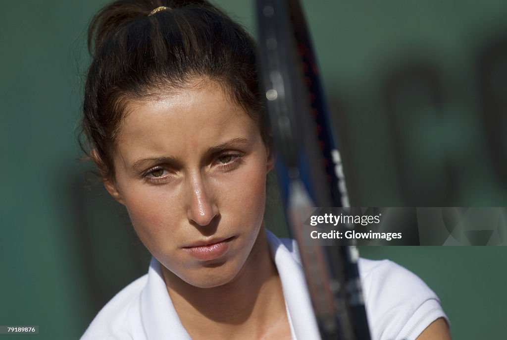 Portrait of a young woman holding a tennis racket