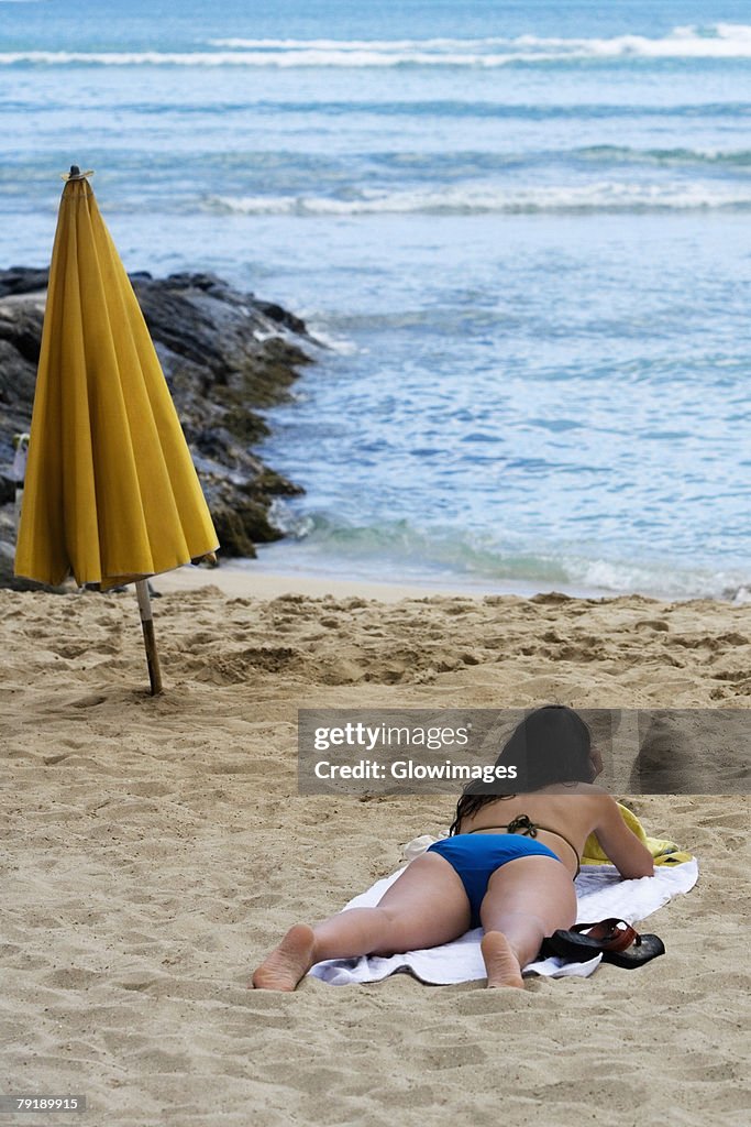 Rear view of a woman lying on the beach, Waikiki Beach, Honolulu, Oahu, Hawaii Islands, USA