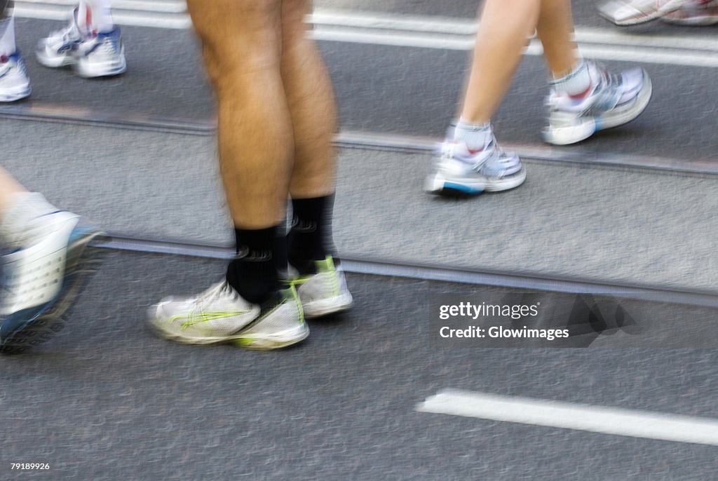 Low section view of male athletes preparing for a sports race on a running track