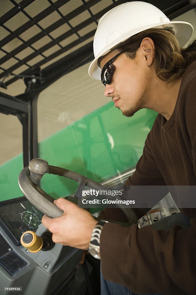 Side profile of a male construction worker operating a crane