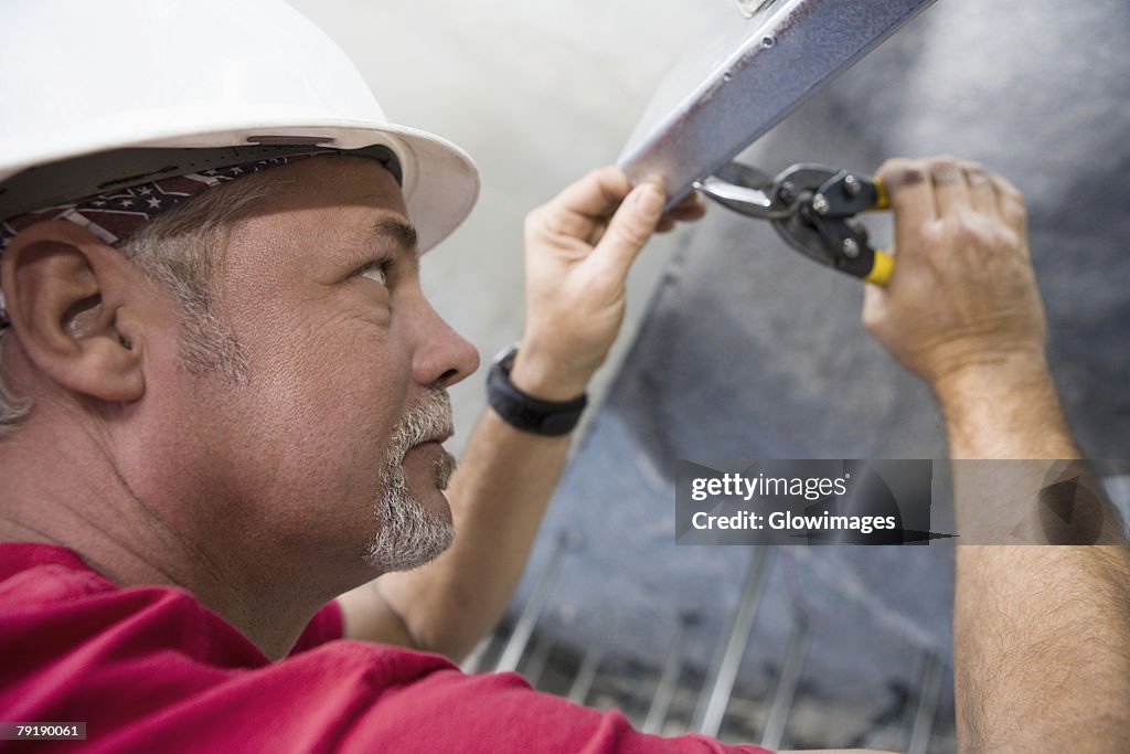 Side profile of a male construction worker working with a wrench