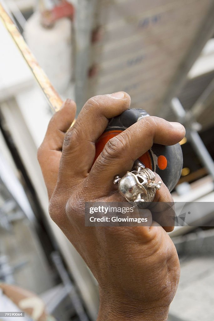 Close-up of a man's hand holding a tape measure