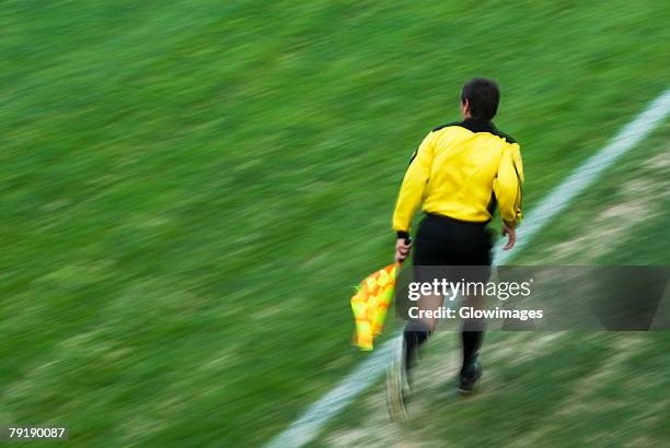 rear view of a referee running on a football pitch - sportdomare bildbanksfoton och bilder