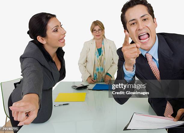 side profile of a businesswoman pointing at another businessman standing in front of her - mean coworker stock pictures, royalty-free photos & images