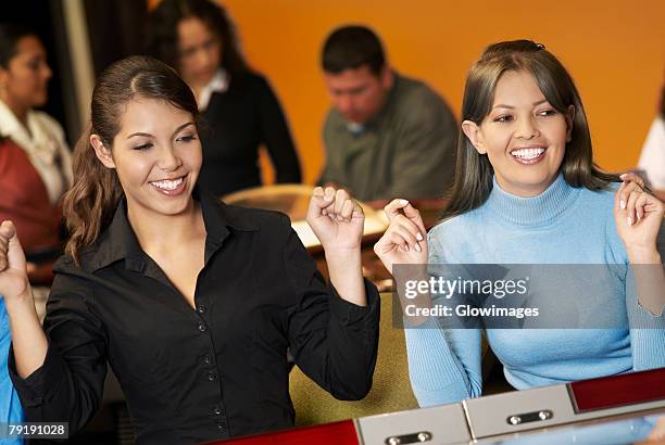 teenage girl with a young woman playing on slot machines - teen pokies stock pictures, royalty-free photos & images