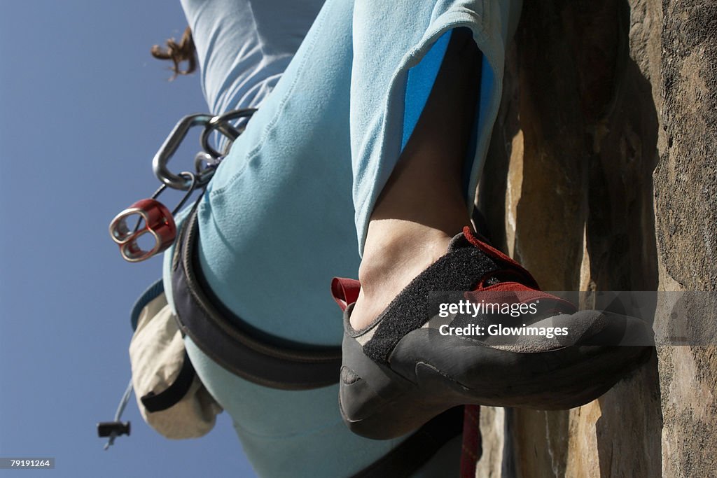 Low section view of a female climber rock climbing