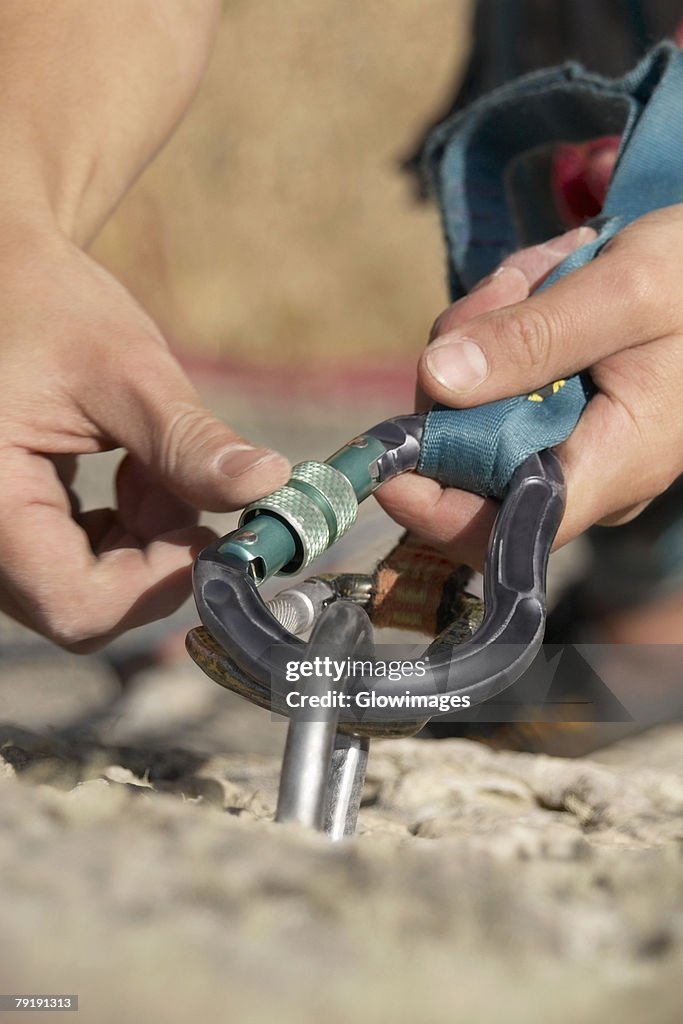 Rock climber concording a carabiner with a hook