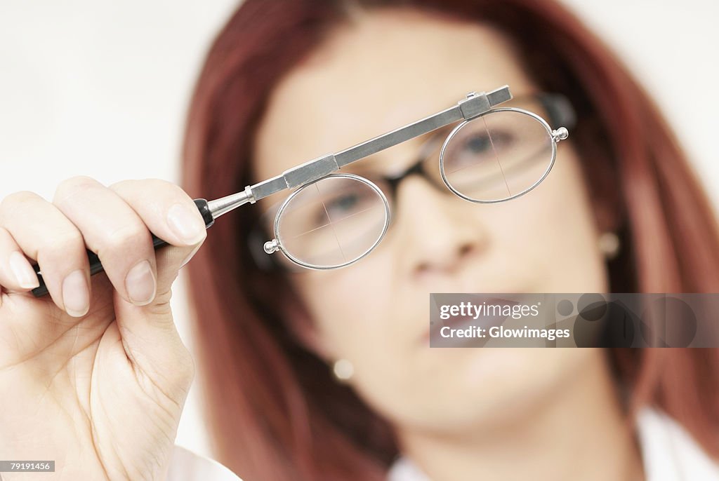 Close-up of a female optometrist holding an eye test equipment