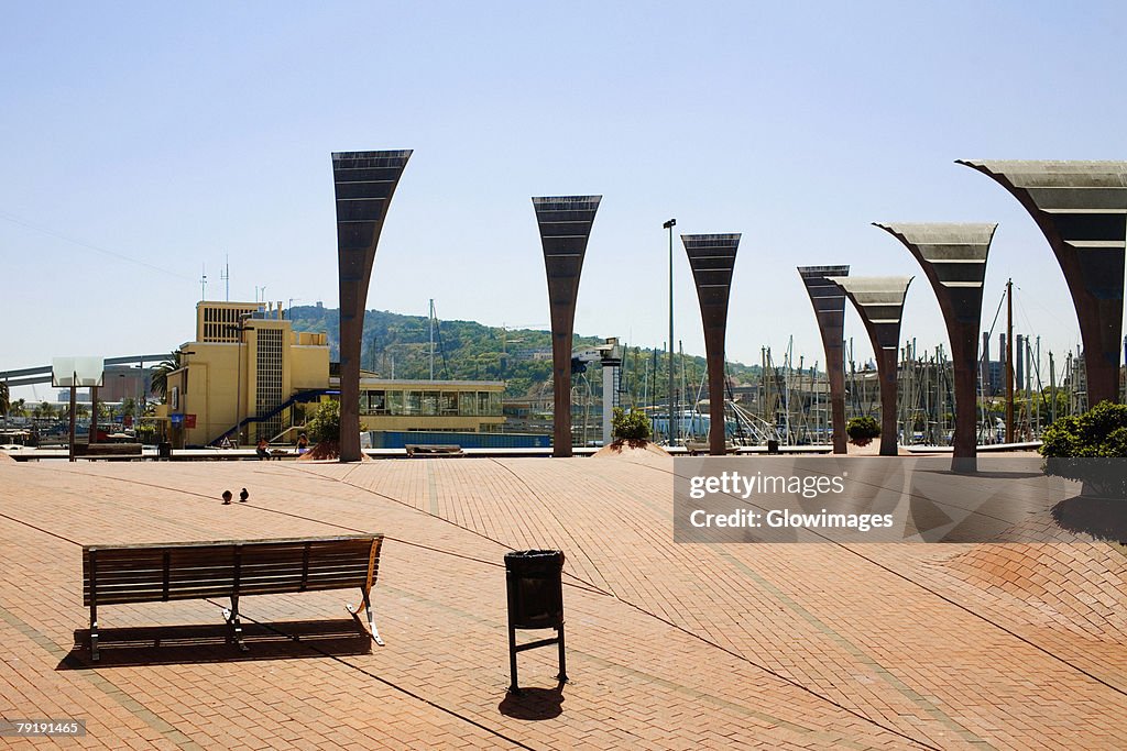 Empty bench near sculptures in a city, Barcelona, Spain