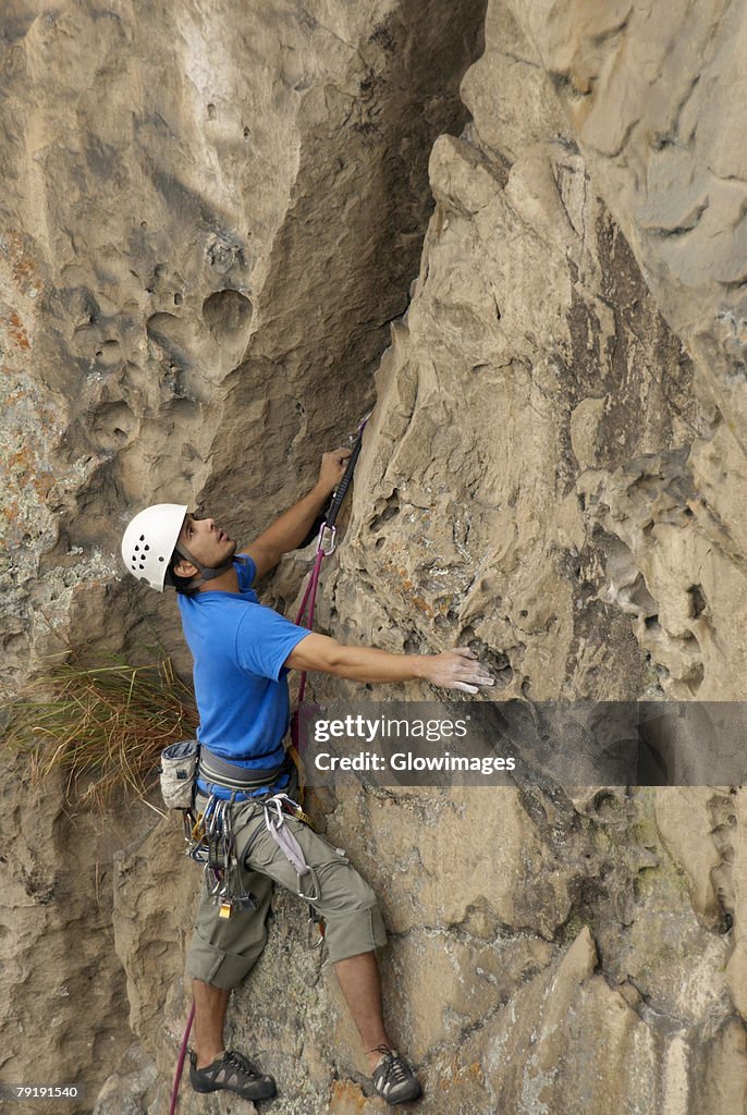 Male rock climber scaling a rock face