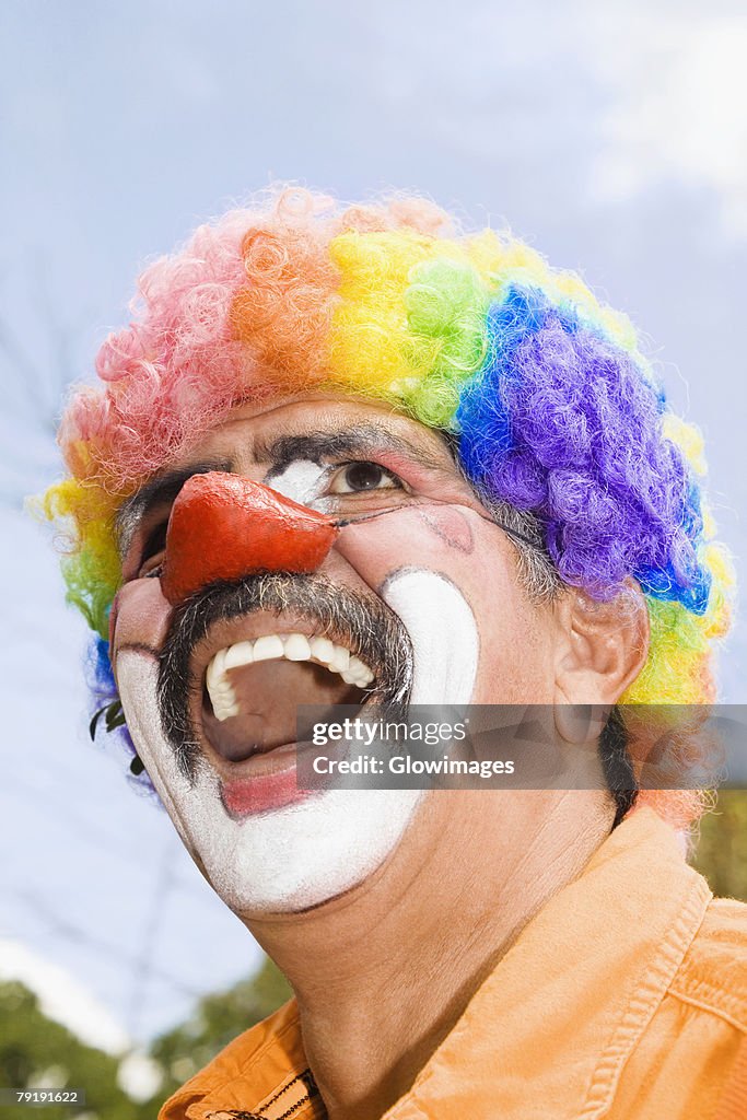 Close-up of a circus clown with a red nose and laughing