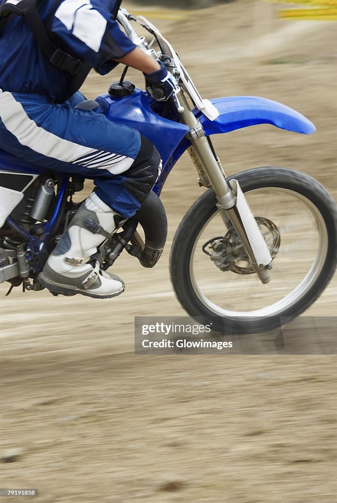 Low section view of a motocross rider riding a motorcycle