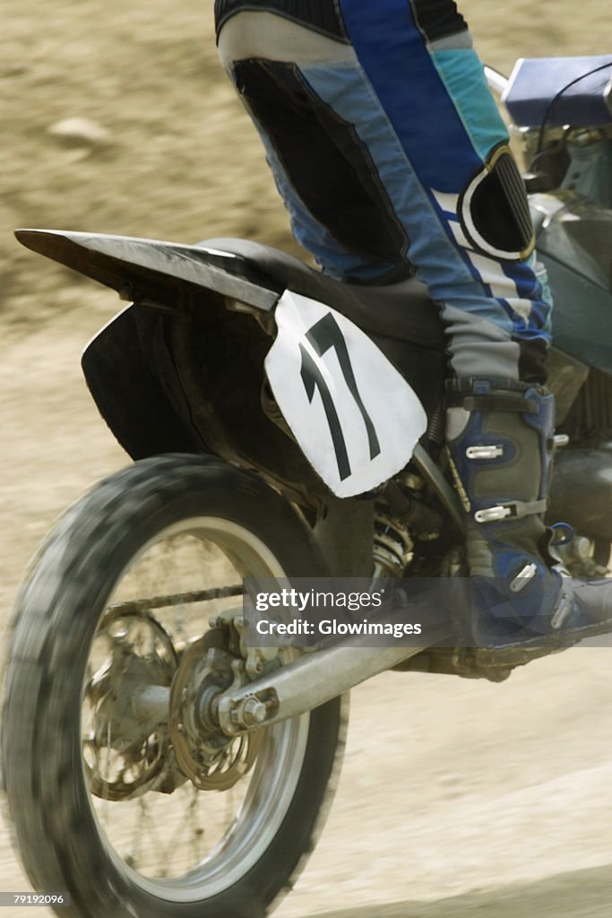 Low section view of a motocross rider riding a motorcycle