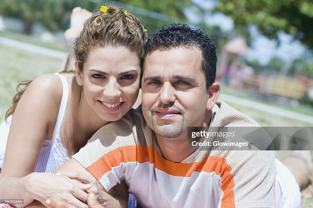 Portrait of a mid adult couple lying in a lawn