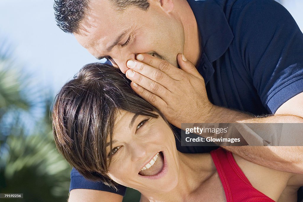 Close-up of a mid adult man whispering into a mid adult woman's ear