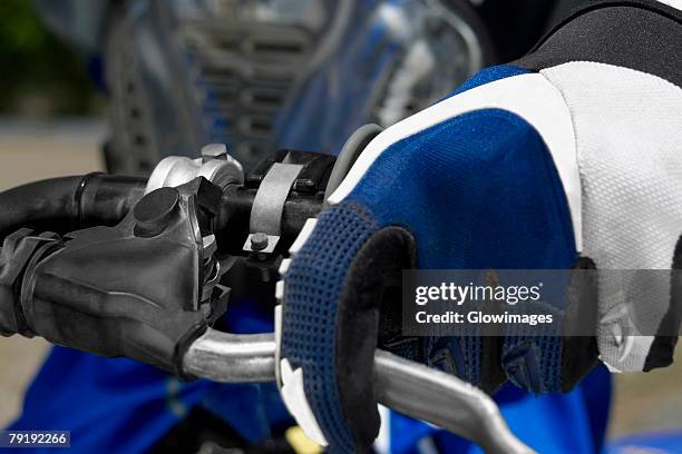 close-up of a motocross rider's hand on the handlebar of a motorcycle - middle finger stock-fotos und bilder