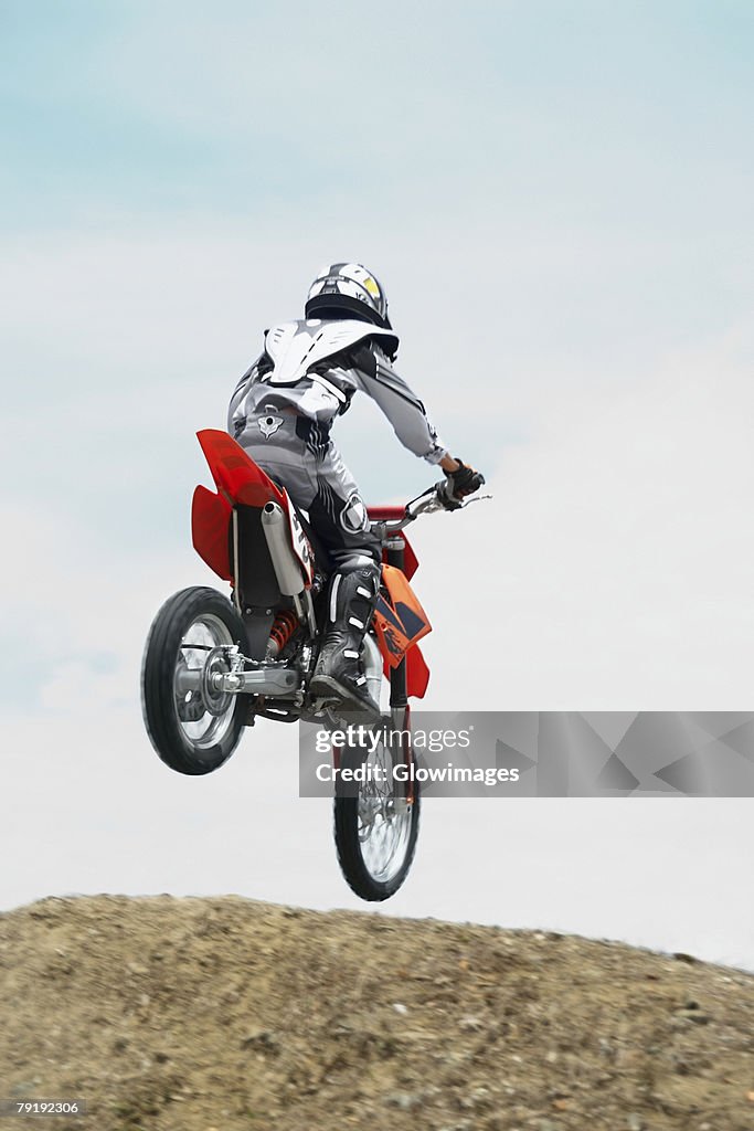 Low angle view of a motocross rider performing a jump on a motorcycle