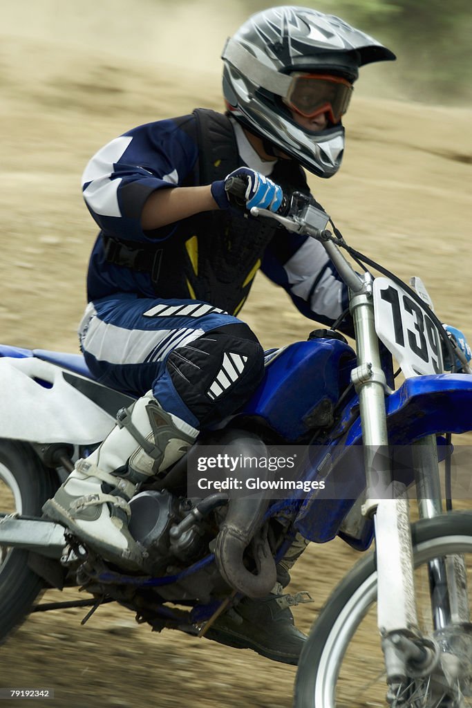 Side profile of a motocross rider riding a motorcycle