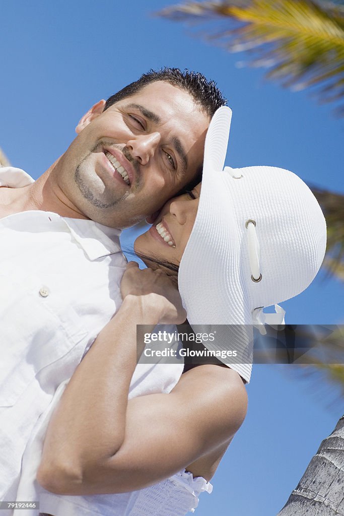 Mid adult woman embracing a mid adult man from behind