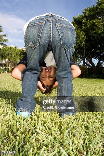 rear view of a boy looking through his legs - vornüber beugen stock-fotos und bilder