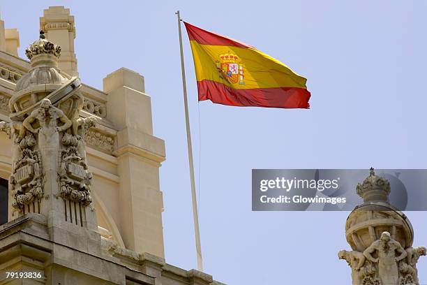 low angle view of a spanish flag fluttering on a building, madrid, spain - spanische flagge stock-fotos und bilder