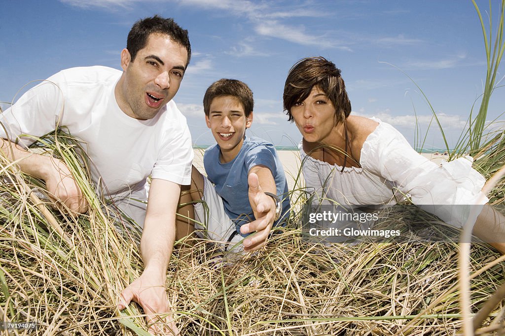 Mid adult couple with their son playing on the beach