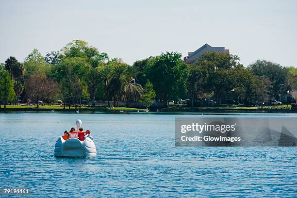 four people on a pedal boat, lake eola park, orlando, florida, usa - pedal boat photos et images de collection