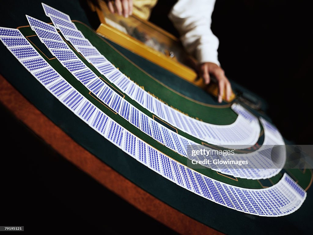 Casino worker dealing with playing cards on a gambling table