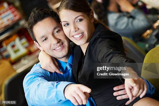 close-up of a mid adult man with his arm around a teenage girl in a casino and pointing forward - teen pokies stock pictures, royalty-free photos & images