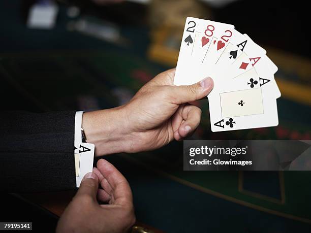 close-up of a person's hand holding playing cards and hiding an ace in his cuff - ace of clubs stock pictures, royalty-free photos & images