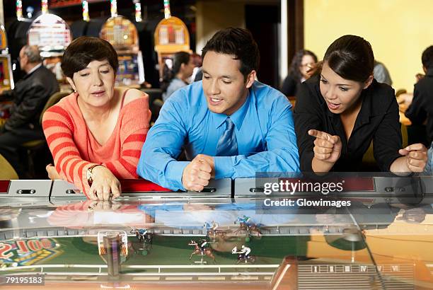 mature woman with a mid adult man and a teenage girl leaning on a casino - teen pokies stock pictures, royalty-free photos & images