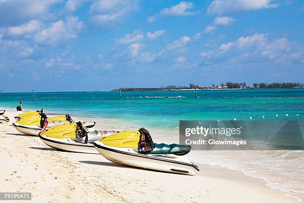 jet boats on the beach, cable beach, nassau, bahamas - nassau beach stock pictures, royalty-free photos & images