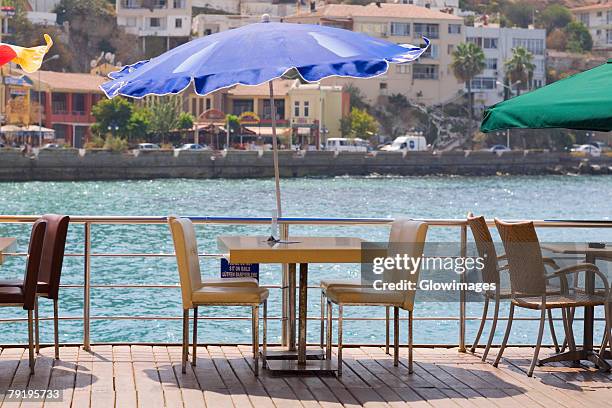 chairs and tables in a restaurant at the seaside, ephesus, turkey - gartenschirm stock-fotos und bilder